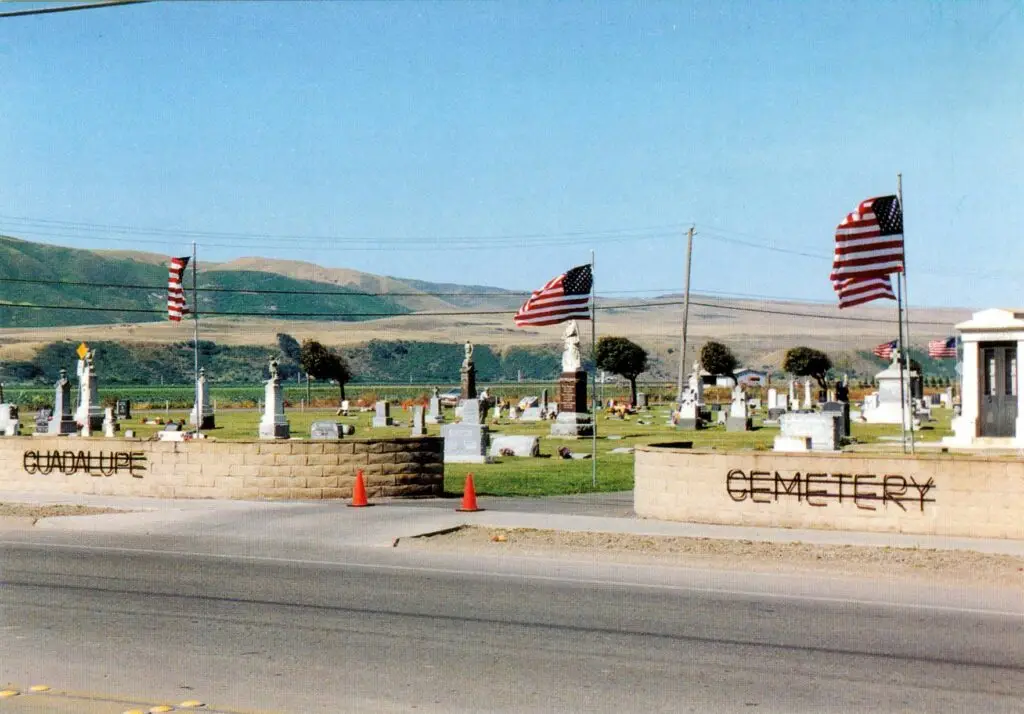 Scenic view of Guadalupe Cemetery District in Guadalupe, CA, with American flags and historic memorials.