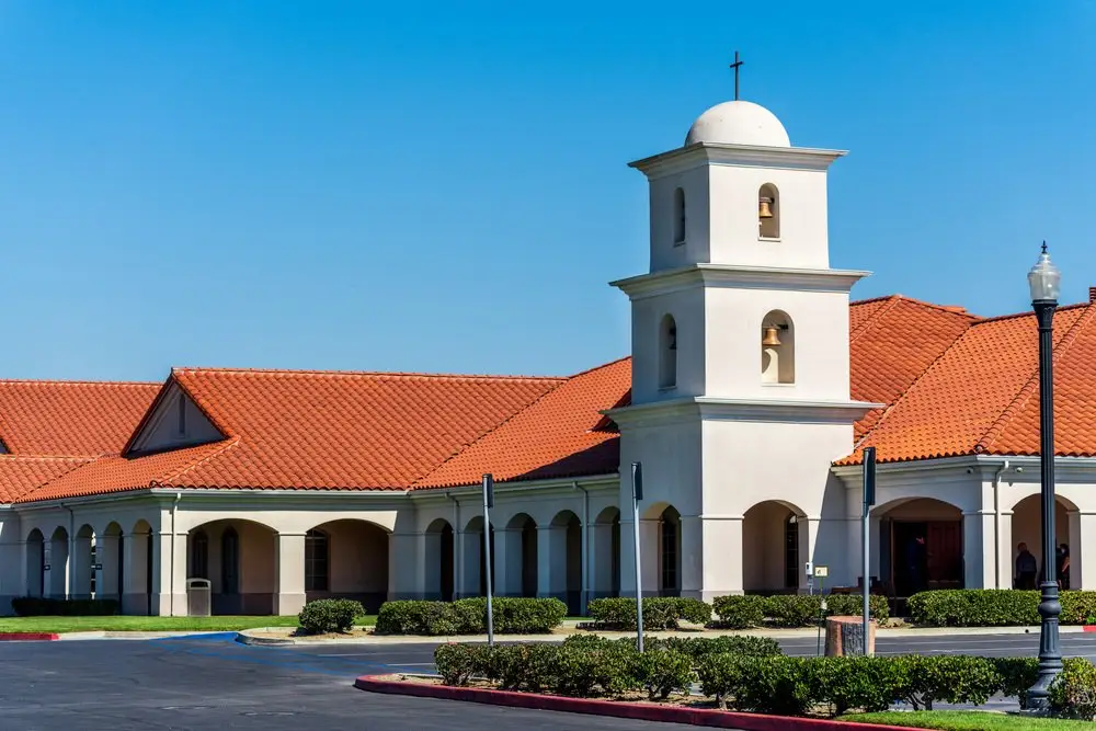 All Souls Mortuary Chapel in Long Beach, featuring Spanish-style architecture with a red-tiled roof and bell tower.