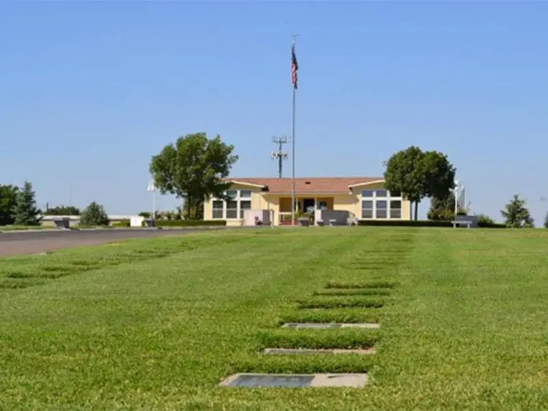 Floral Memorial Park cemetery with lush green grass, flat grave markers, and a peaceful memorial setting.