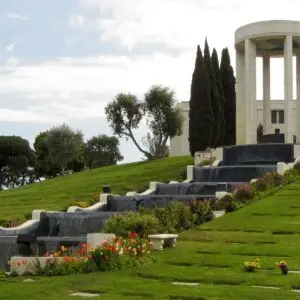 Scenic view of Al Jolson Fountain at Hillside Memorial Park, surrounded by lush greenery and elegant waterfalls.