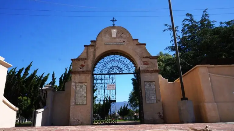 The historic arched entrance of San Gabriel Mission Cemetery in San Gabriel, CA, showcasing its intricate wrought iron gate and timeless architecture.