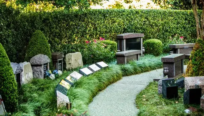 A peaceful cemetery garden at Mt. View Mortuary & Cemetery in San Bernardino, featuring personalized memorials surrounded by lush greenery.