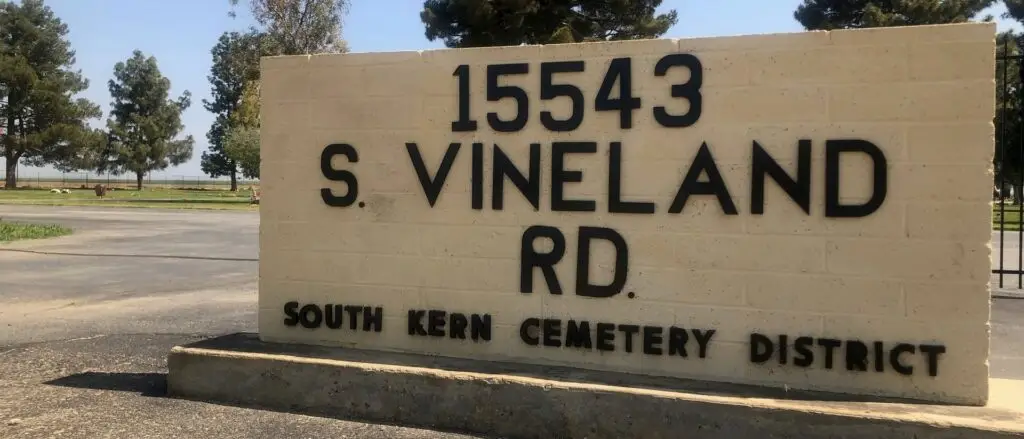 Entrance sign of South Kern Cemetery District at 15543 S. Vineland Rd, Bakersfield, CA, with a view of the cemetery grounds in the background.