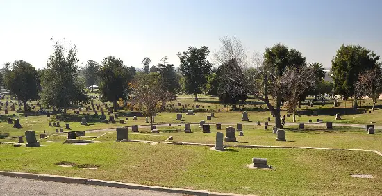 Scenic view of Sunnyside Cemetery with historic headstones, green landscapes, and a peaceful memorial setting.