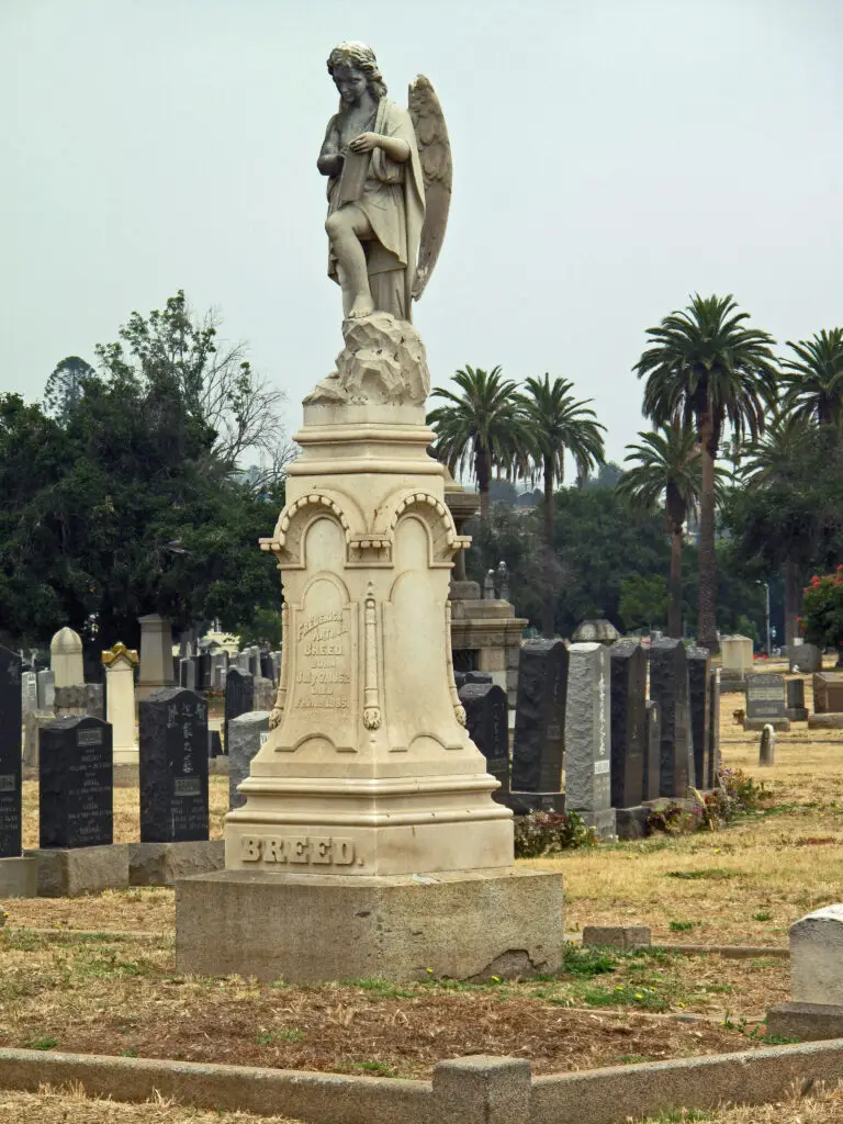 Angel monument at Evergreen Cemetery, Los Angeles, surrounded by historic gravestones.