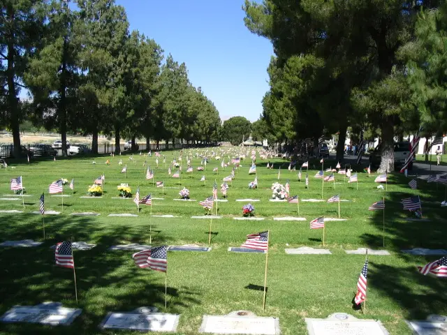 American flags placed on graves at West Side Cemetery District during Memorial Day, honoring veterans and loved ones.