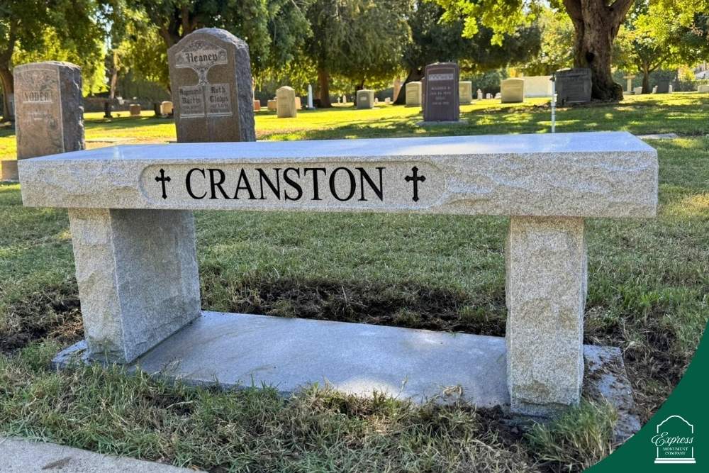 Granite bench memorial for Cranston with engraved name and crosses, cemetery background